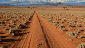 Empty dirt road in the vast desert landscape of Namibia.