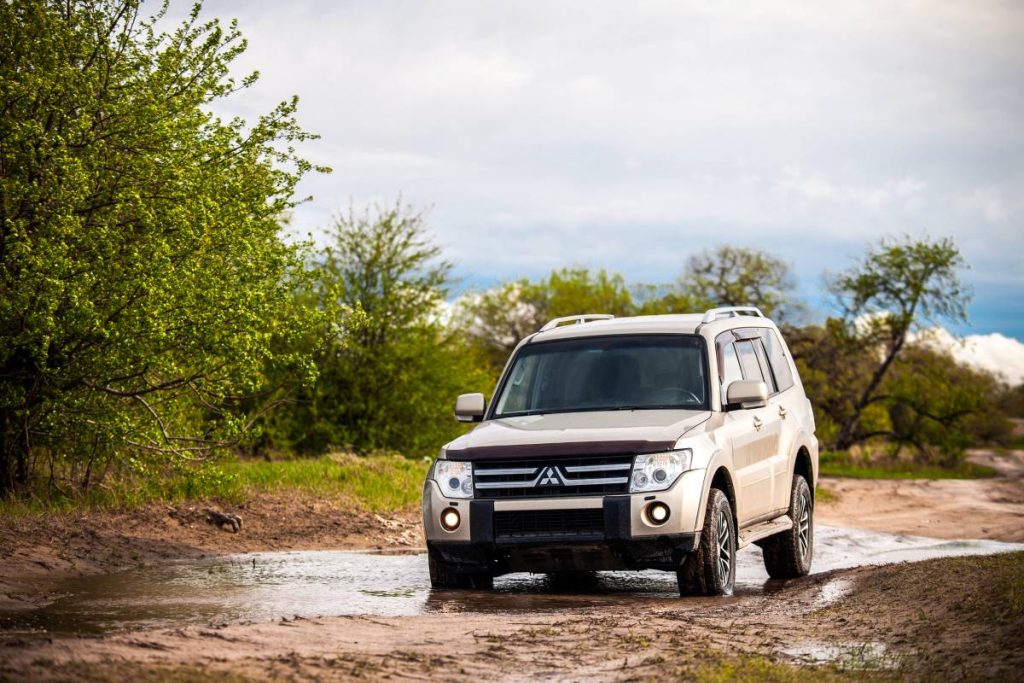 A Mitsubishi Pajero drives through muddy water.