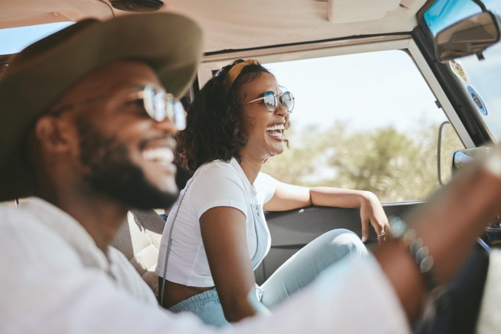 A smiling couple driving a car.