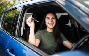 Woman with keys in hand proud of getting the licence to drive on public roads.