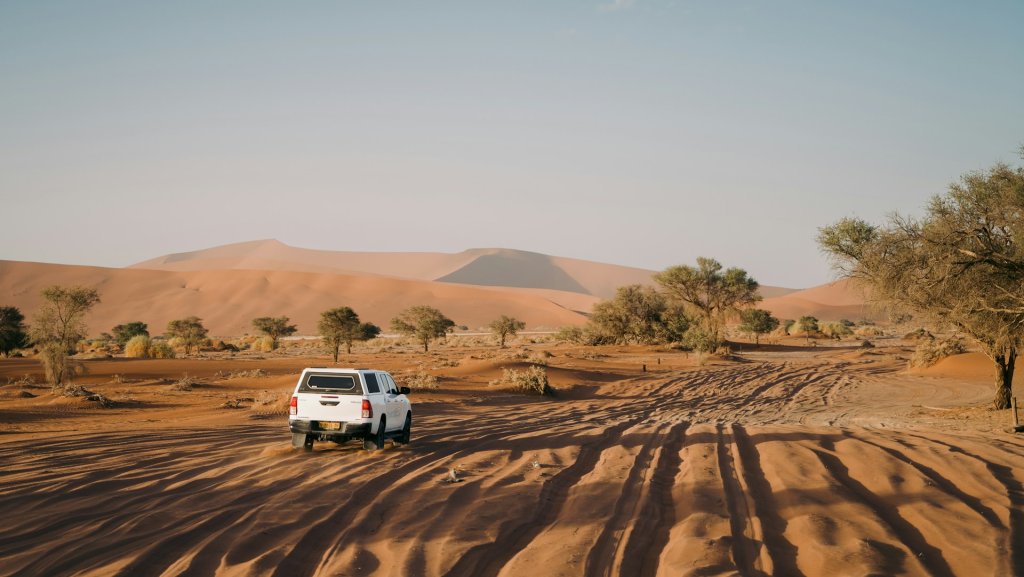A 4x4 driving through the thick sand at Sossusvlei, Namibia.