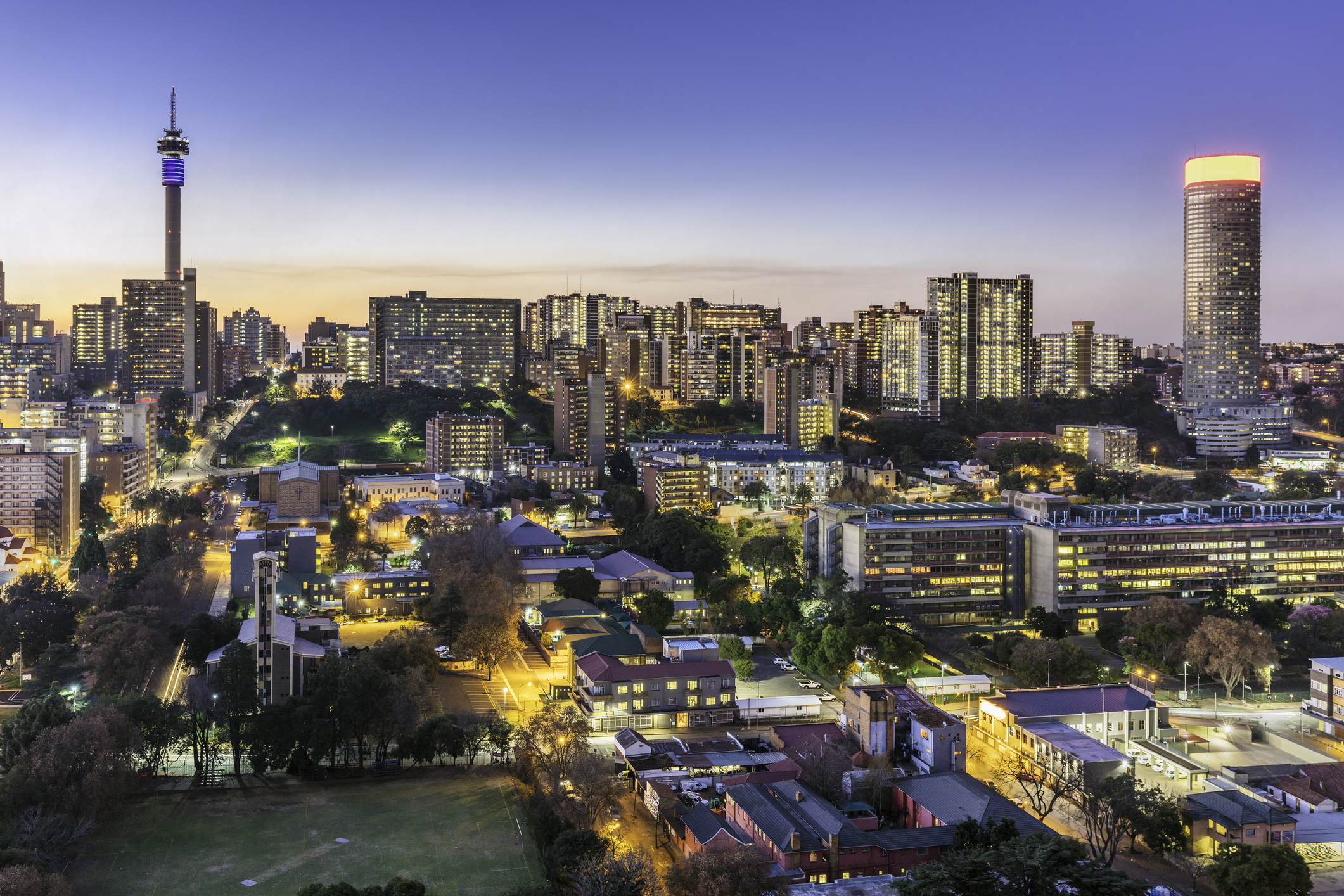 Johannesburg-Stadtbild-Panorama-Sonnenuntergang mit dem Wohnvorort und dem berühmten Telkom-Kommunikationsturm bis zum Ponte-Turm. Johannesburg ist eine der vierzig größten Metropolen der Welt und die größte Stadt der Welt, die nicht an einem Fluss oder am Seeufer liegt , oder Küste. Aufgrund seiner Lage in der mineralreichen Provinz Gauteng ist es auch die Quelle eines groß angelegten Gold- und Diamantenhandels. width=