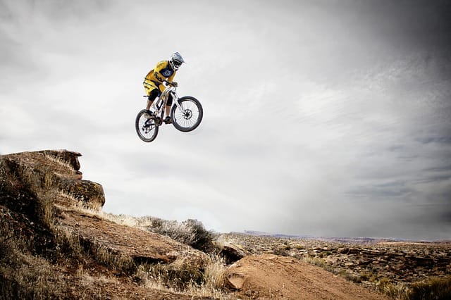 Man riding mountain bike off a hill. Photo: Canva