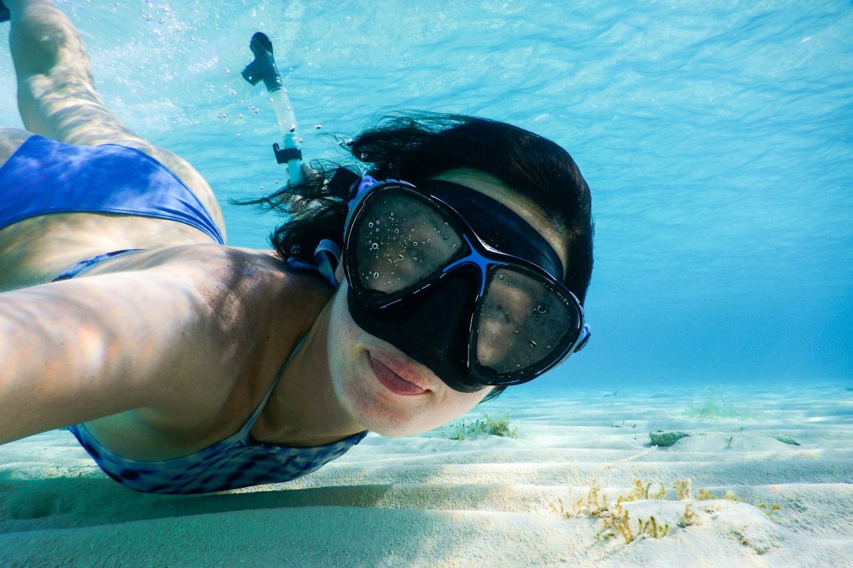 A woman snorkelling in clear blue water.