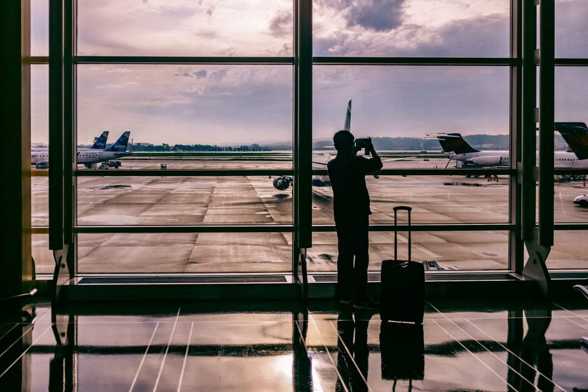 A silhouetted figure in an airport terminal.