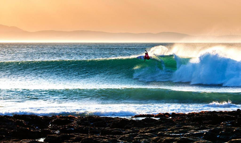 Surfer catching waves in Jeffreys Bay, South Africa