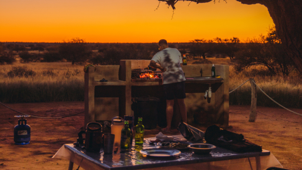 Man cooks over a fire at a campsite in Namibia.