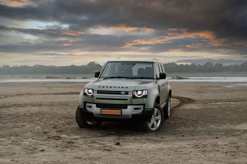 A Land Rover Defender parked in a desert.