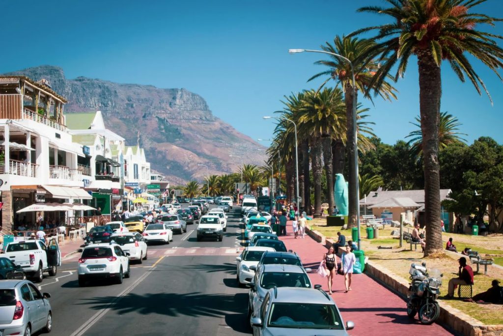 The Camps Bay beachfront with hired cars in Cape Town, South Africa.