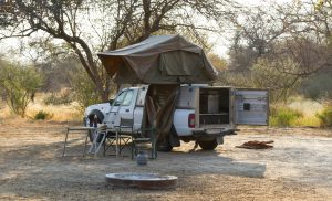 Offroad 4x4 vehicle with tent in the roof ready for camping in the desert