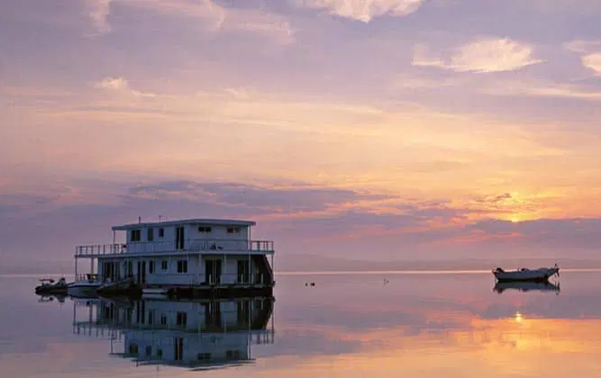 A houseboat on the water during a sunset in Zambia
