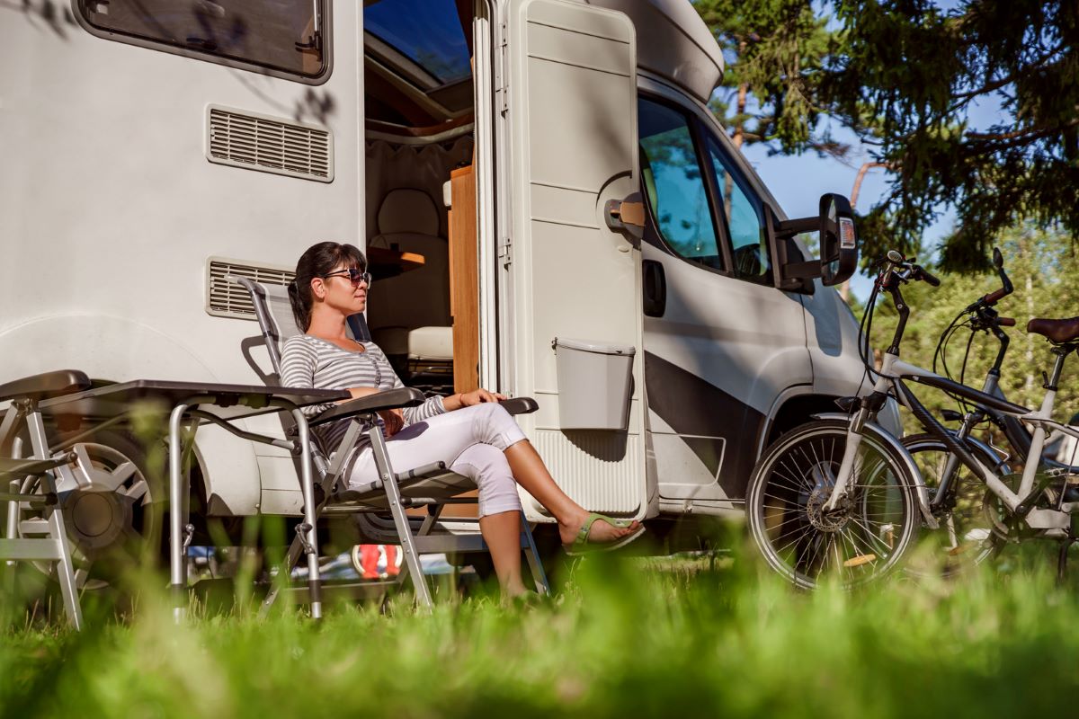 A woman sitting outside an RV rental in South Africa.