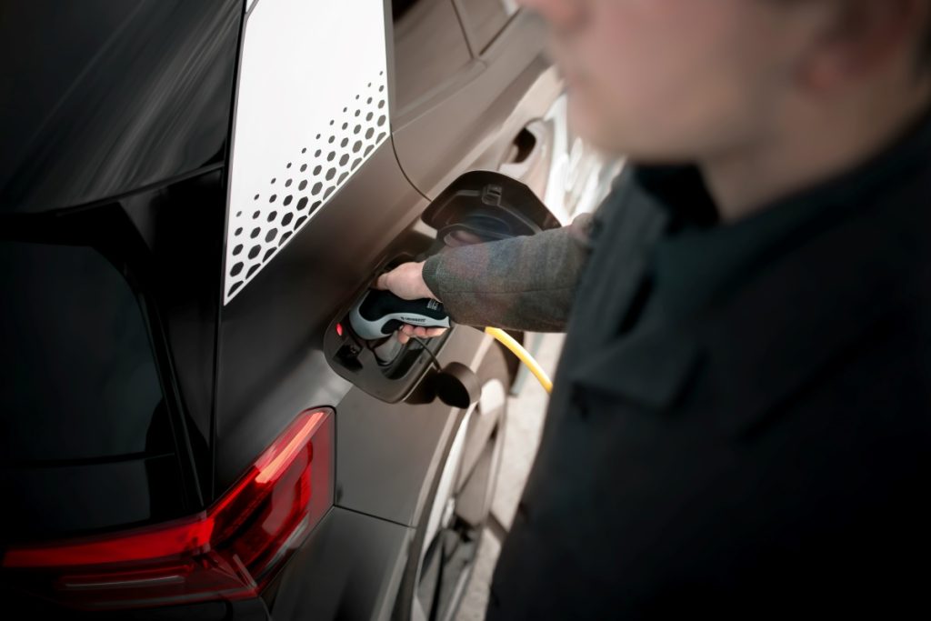 A man charges his EV.