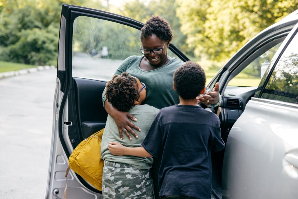 A family hugging on a road trip.