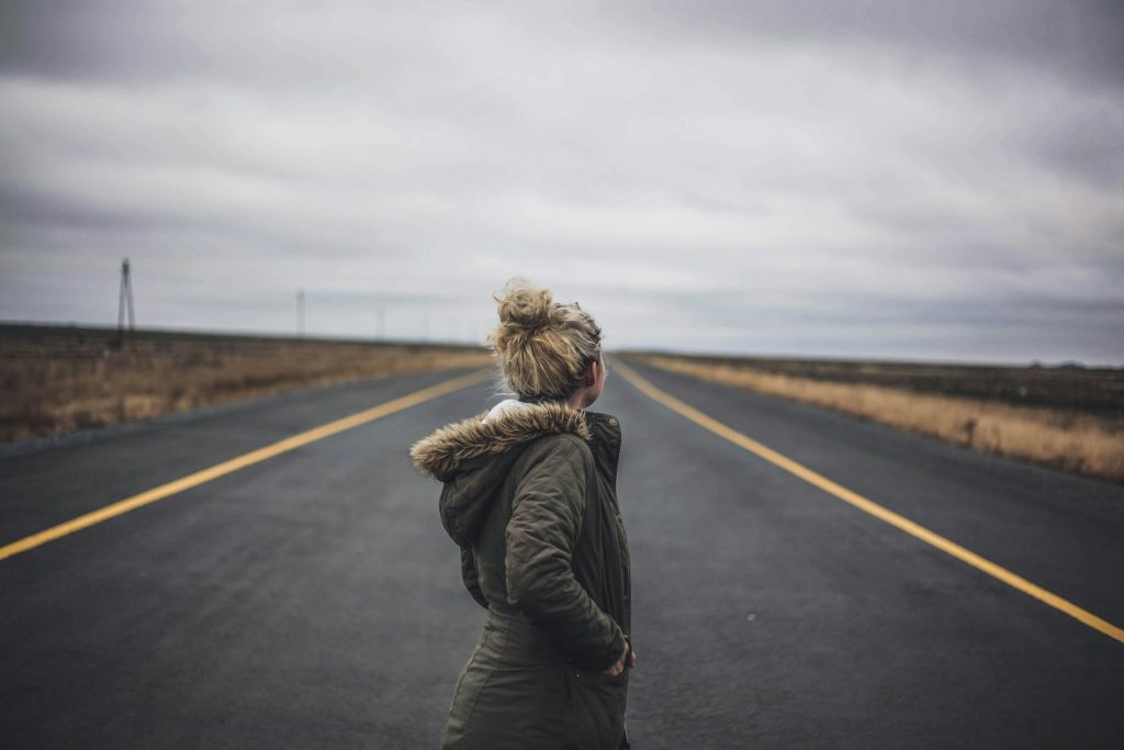 A woman standing in the middle of the road.