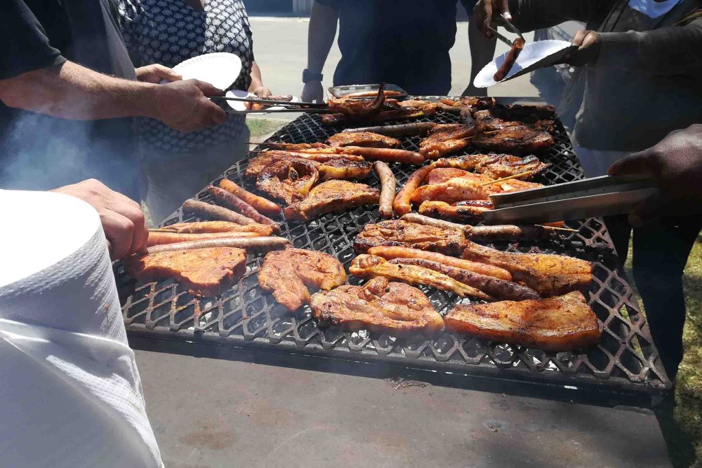 South African people braaing (cooking) meat together.