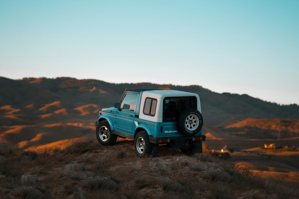 A Suzuki Jimny on a hilltop.