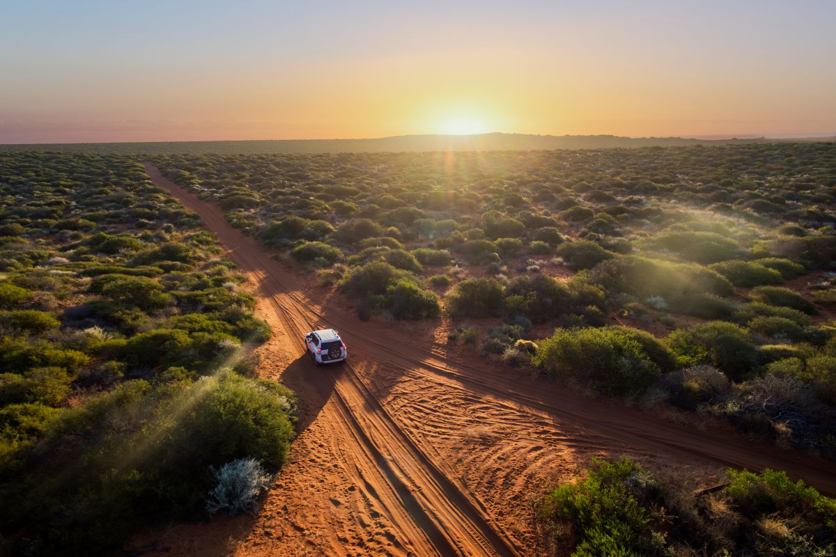 A Land Cruiser drives through sand in Africa.