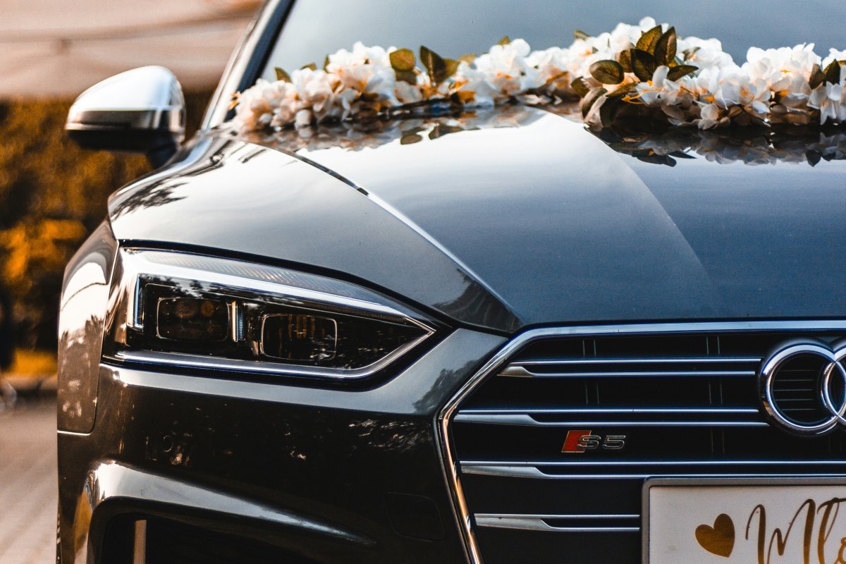 A luxury car with flowers on the hood.