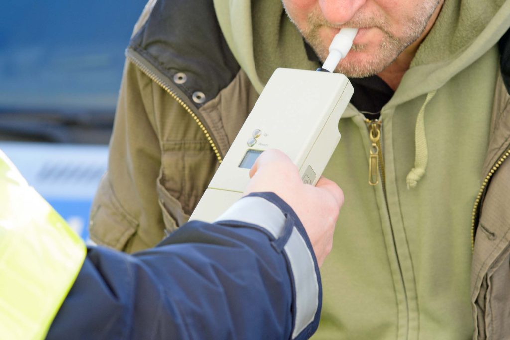 A man takes a breathalyser test.