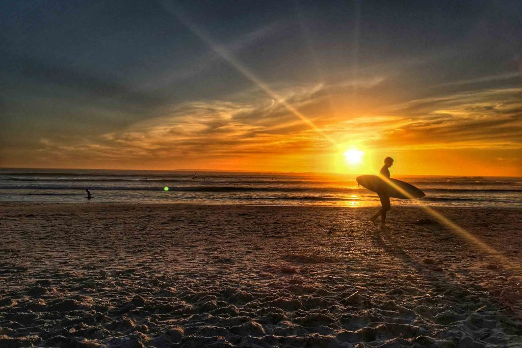 A surfer walks along Clifton beach in Cape Town.