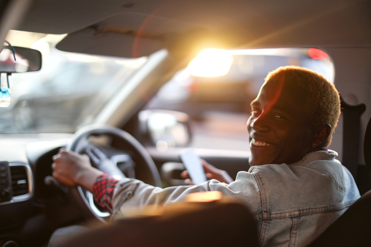 A dark skinned man in a car in South Africa.