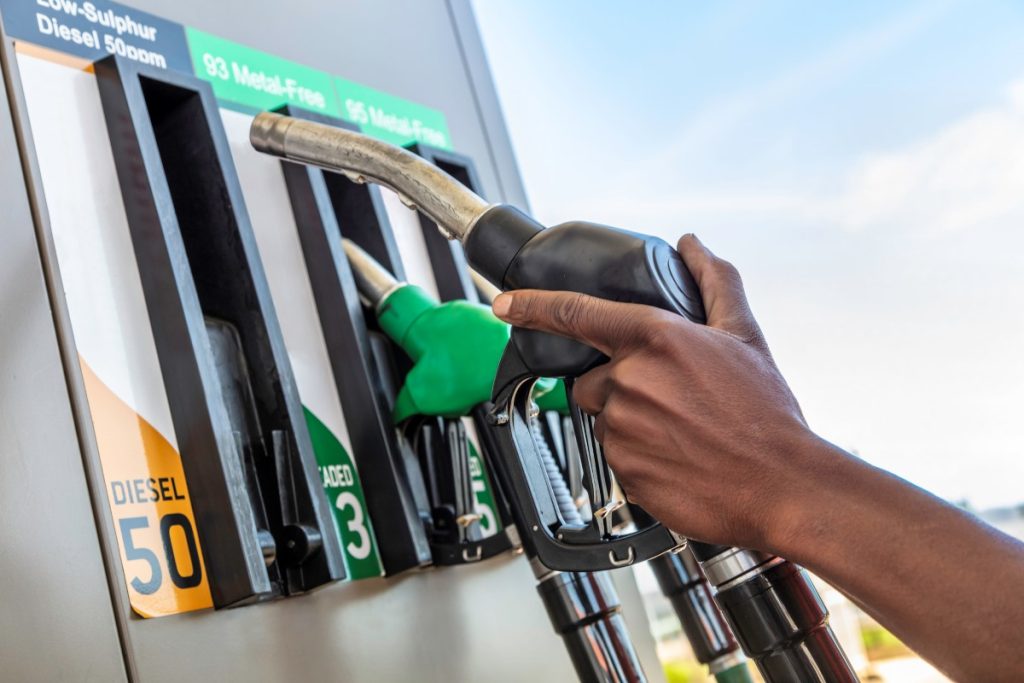 A person gets ready to pump petrol.