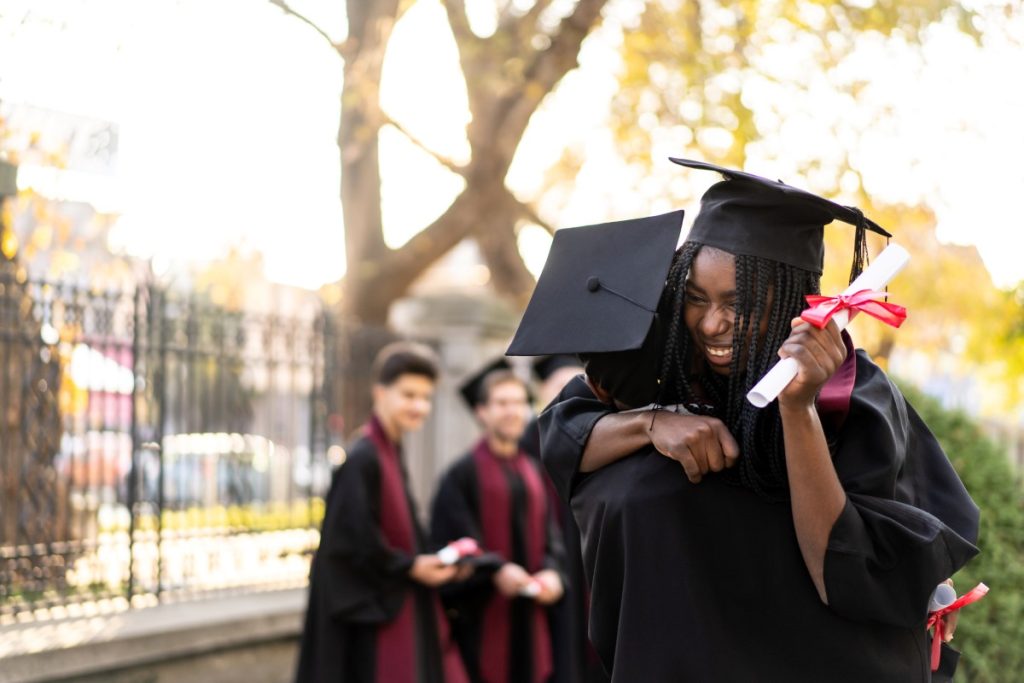 Friends embrace at their university graduation.