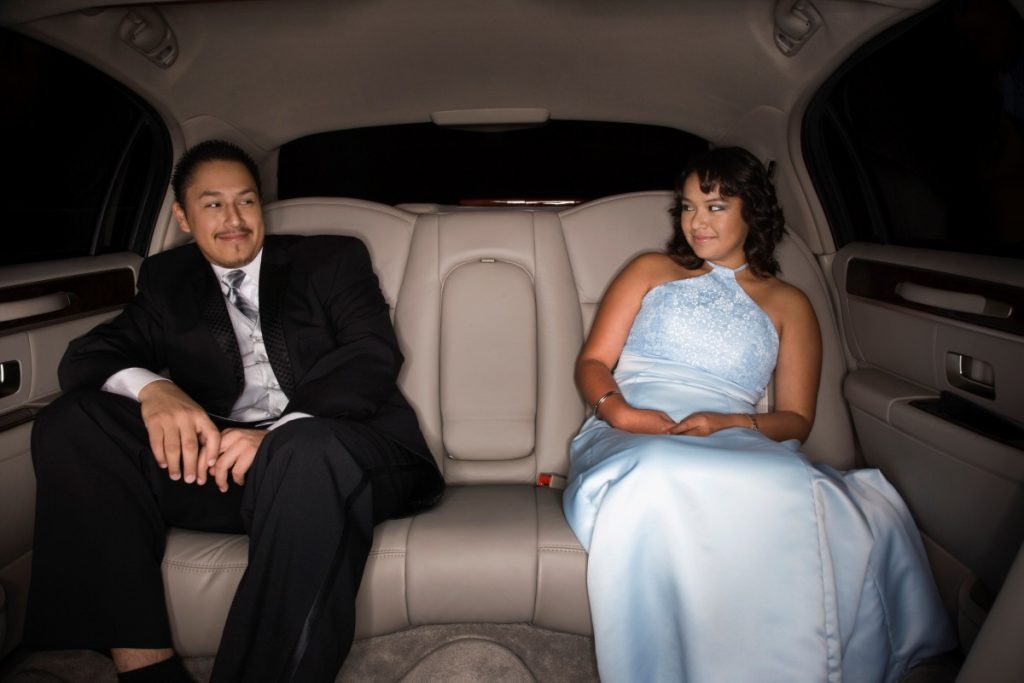 A couple in the back seat of their luxury car for their Matric Dance.