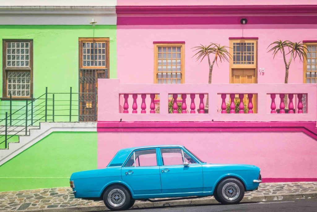 A blue car in front of colourful houses in Bo-Kaap.