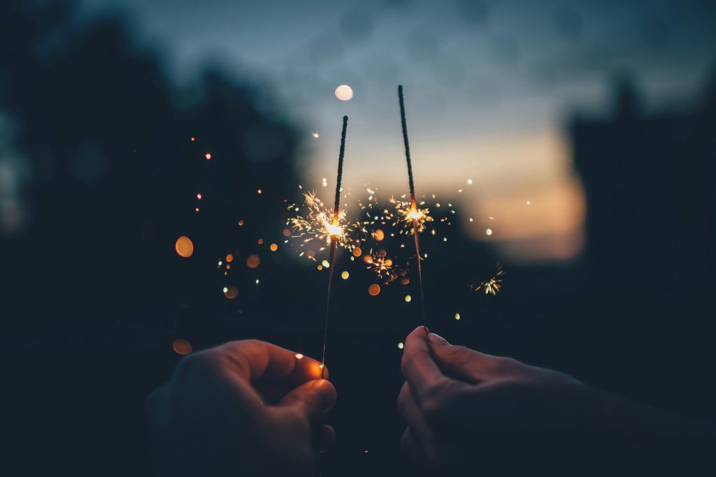 Two people hold sparklers.