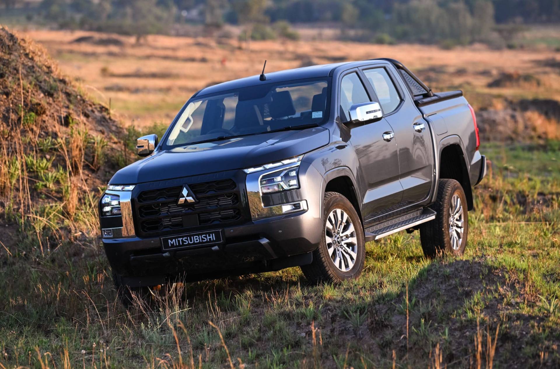 Uitzicht op een Mitsubishi Triton geparkeerd op een veld