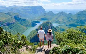 A couple at the peak looking out over the Blyde River Canyon Nature Reserve in Mpumalanga, South Africa.