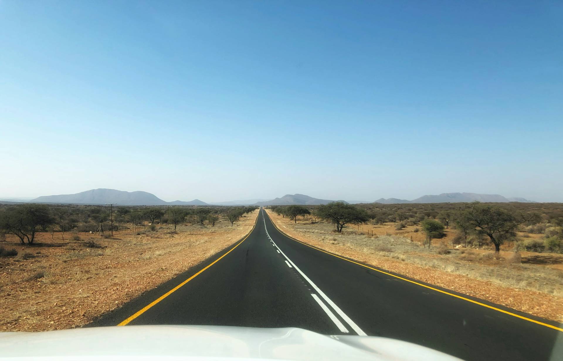 Car driving on a long road | Photo: Bernd Dittrich via Unsplash