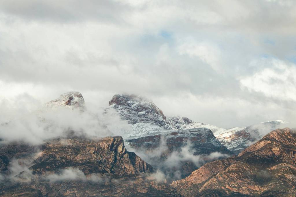 Mountains covered in snow surrounded by clouds