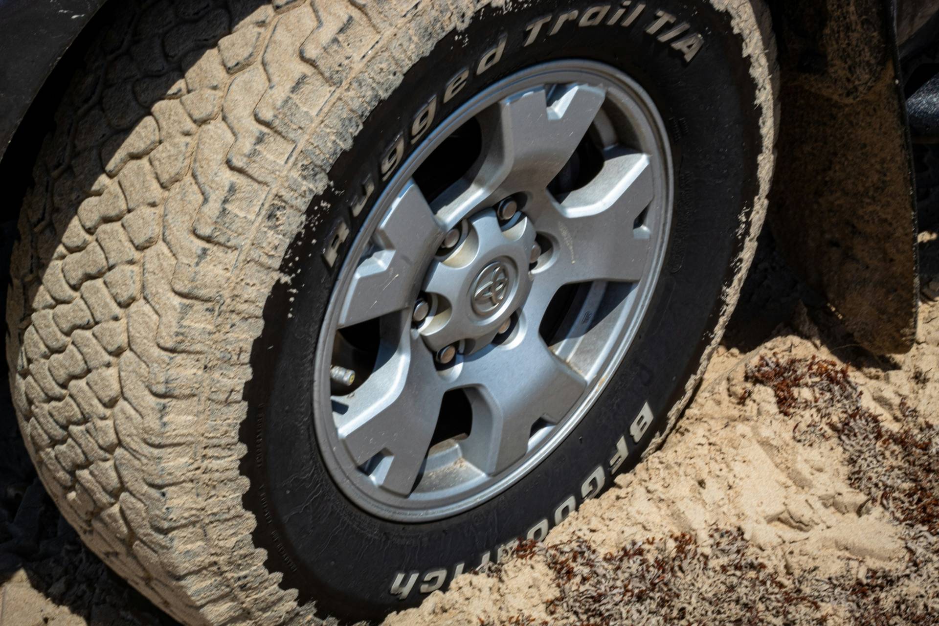 Uplclose shot of a tire driving through a sandy road