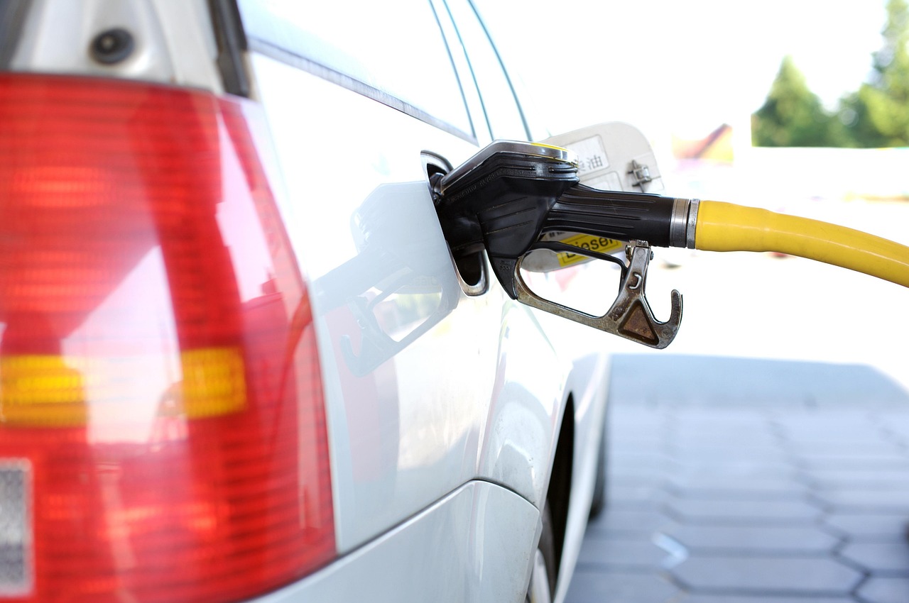 A white car getting refuelled at a petrol station