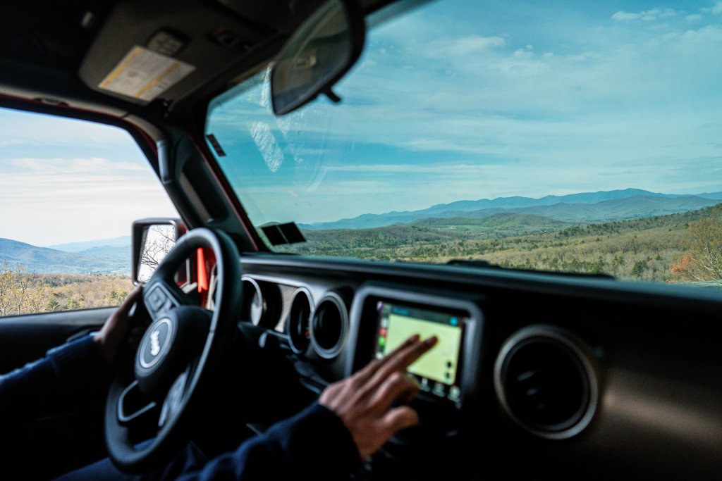 A driver setting a GPS in the car.