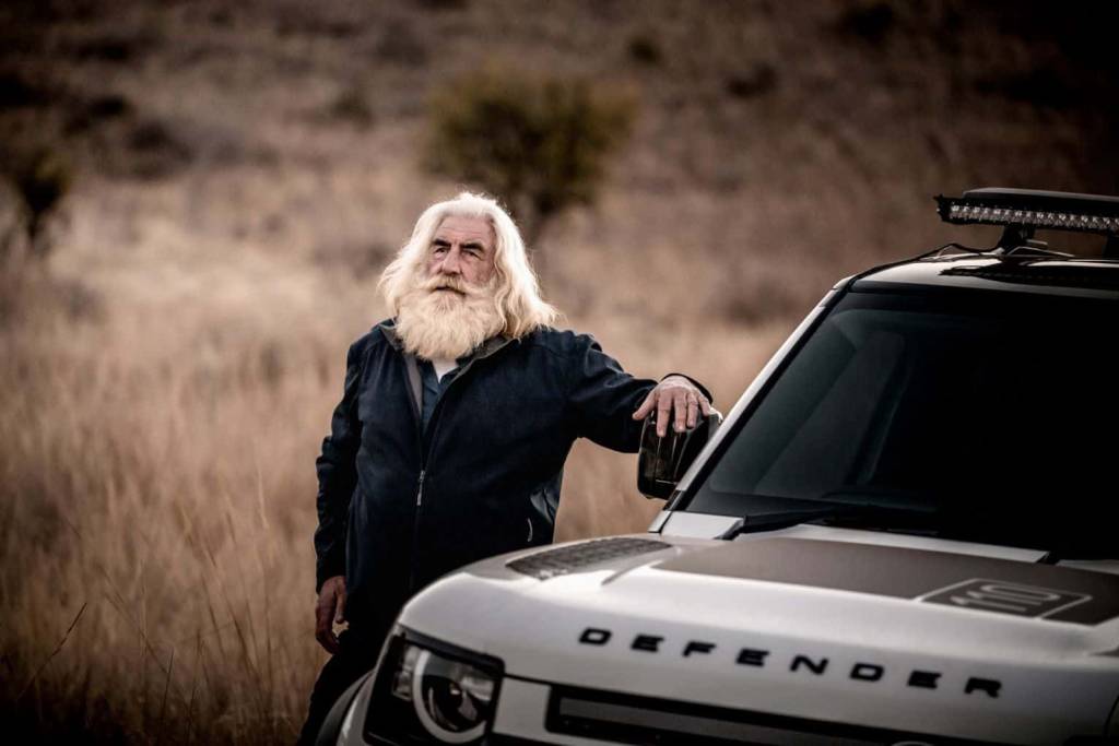 Kingsley Holgate standing next to a Land Rover Defender