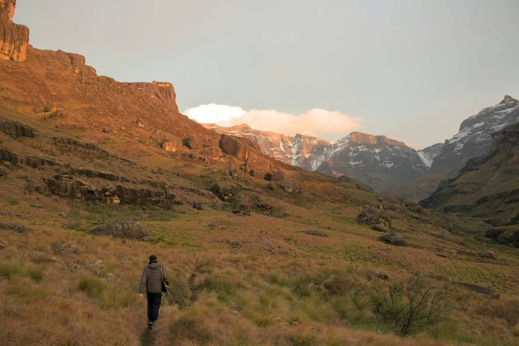 A person hiking in the mountains at sunrise.