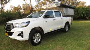An equipped Toyota Hilux Double Cab Bushcamper parked at a campsite.