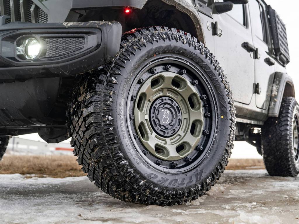 A 4x4 on an icy road and the wheels are in dirt and ice.