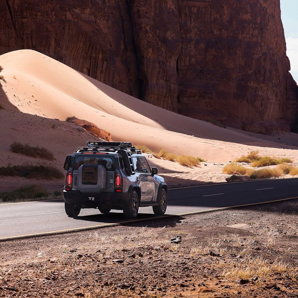A Jetour T2 driving along a road with mountains to the side.