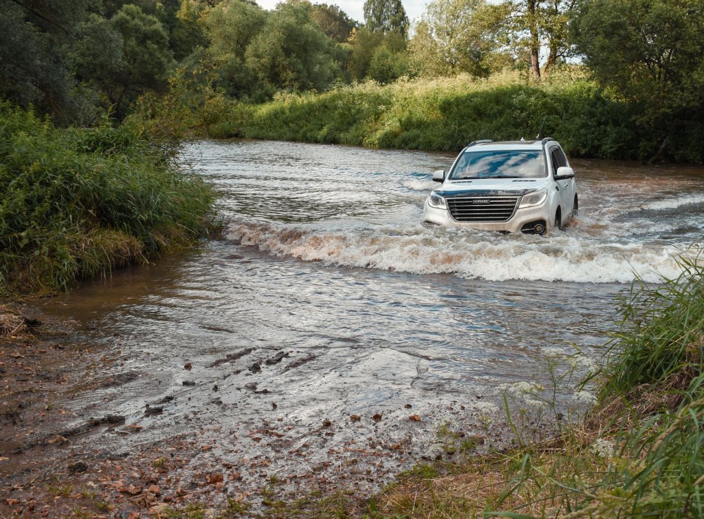 4x4 vehicle driving across a river.